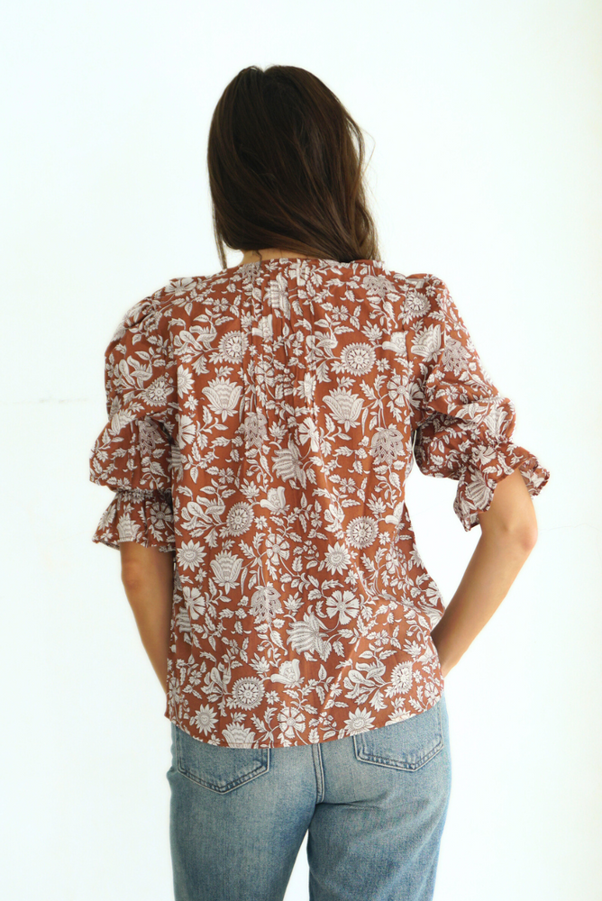 
                      
                        Back view of the Chloe Shirt in brown floral, showcasing its voluminous shape and relaxed fit from behind.
                      
                    