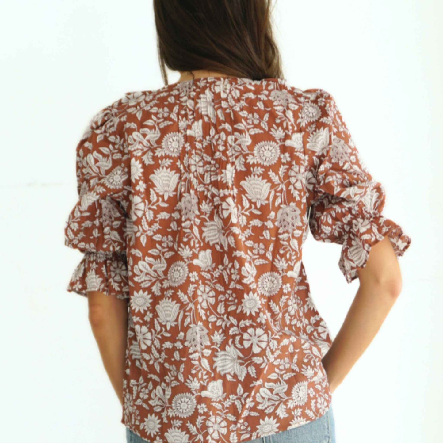 Close-up of ruffle neckline and pin-tuck detailing