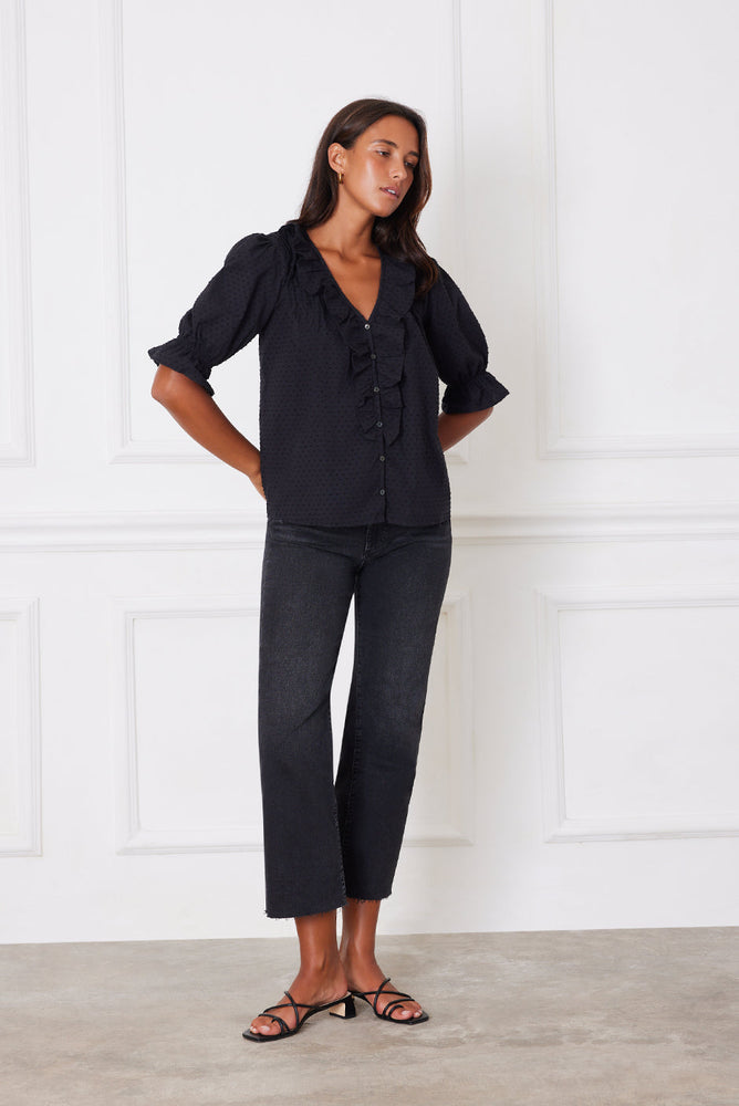 
                      
                        Right side studio view of the Chloe Shirt in black, styled with black pants to show off the soft drape and delicate silhouette.
                      
                    