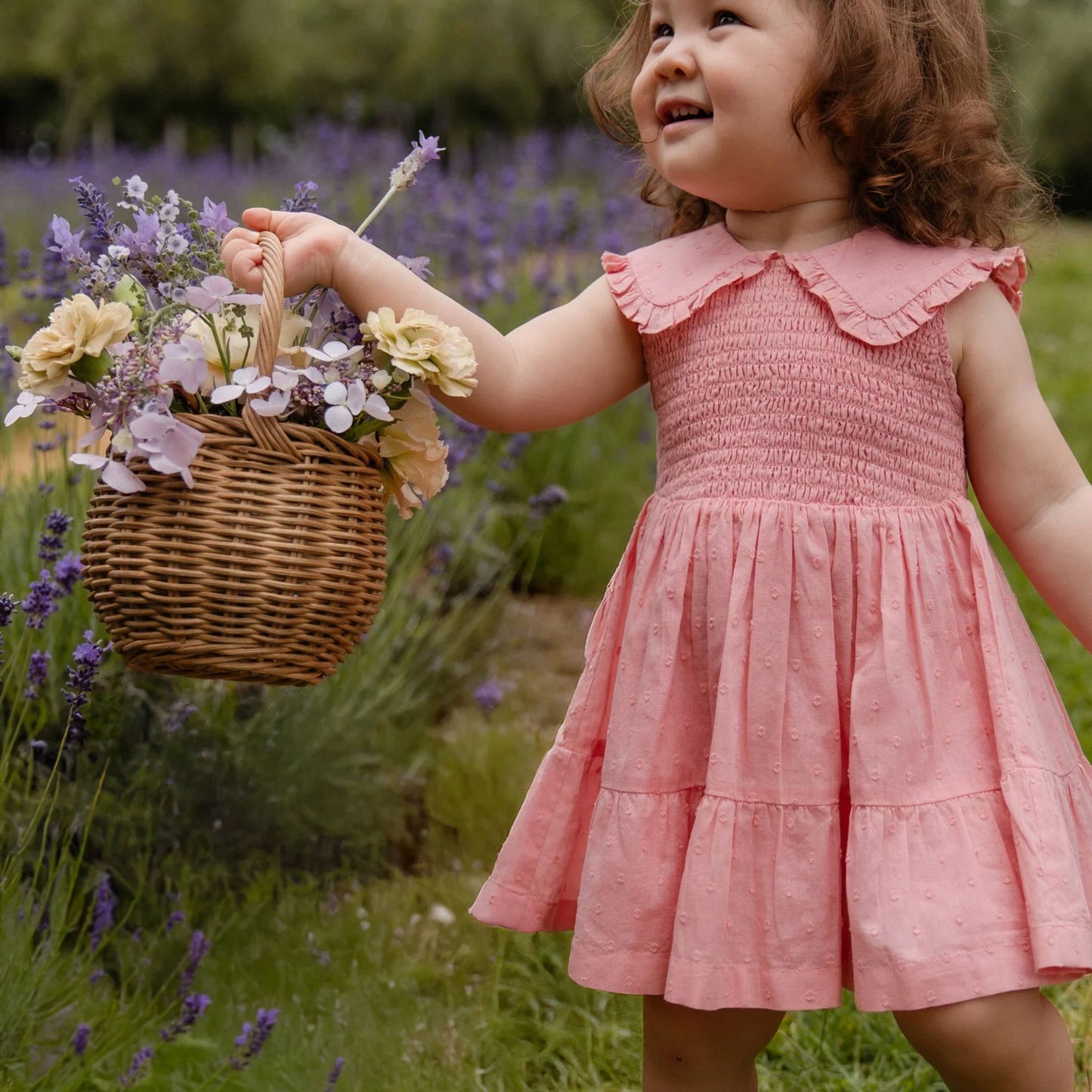 Child wearing Jamie Kay Organic Cotton Claudine Dress in Swiss Pink
