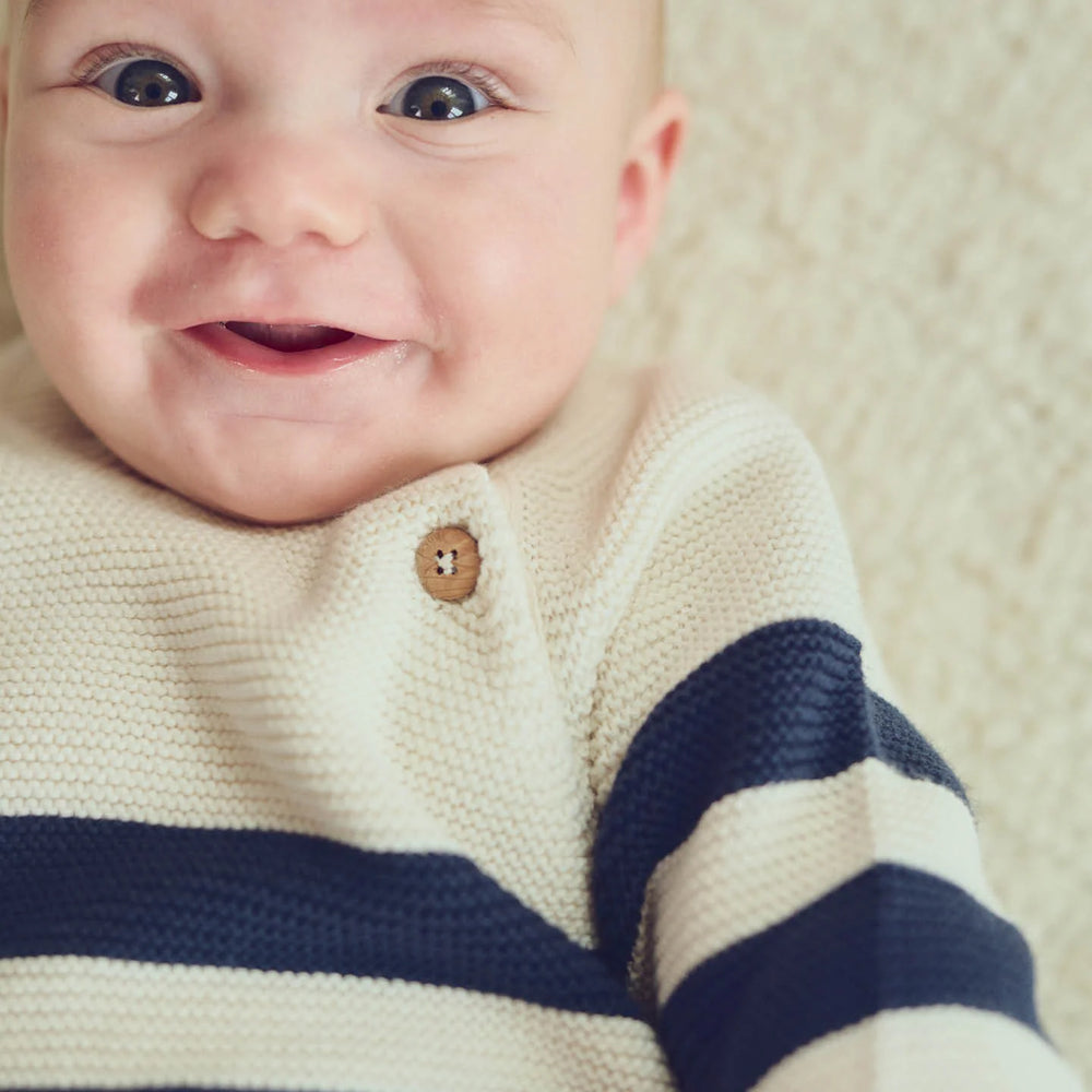 Close-up of the Musli Knit Stripe Sweater showing soft organic knit fabric and functional shoulder button detail