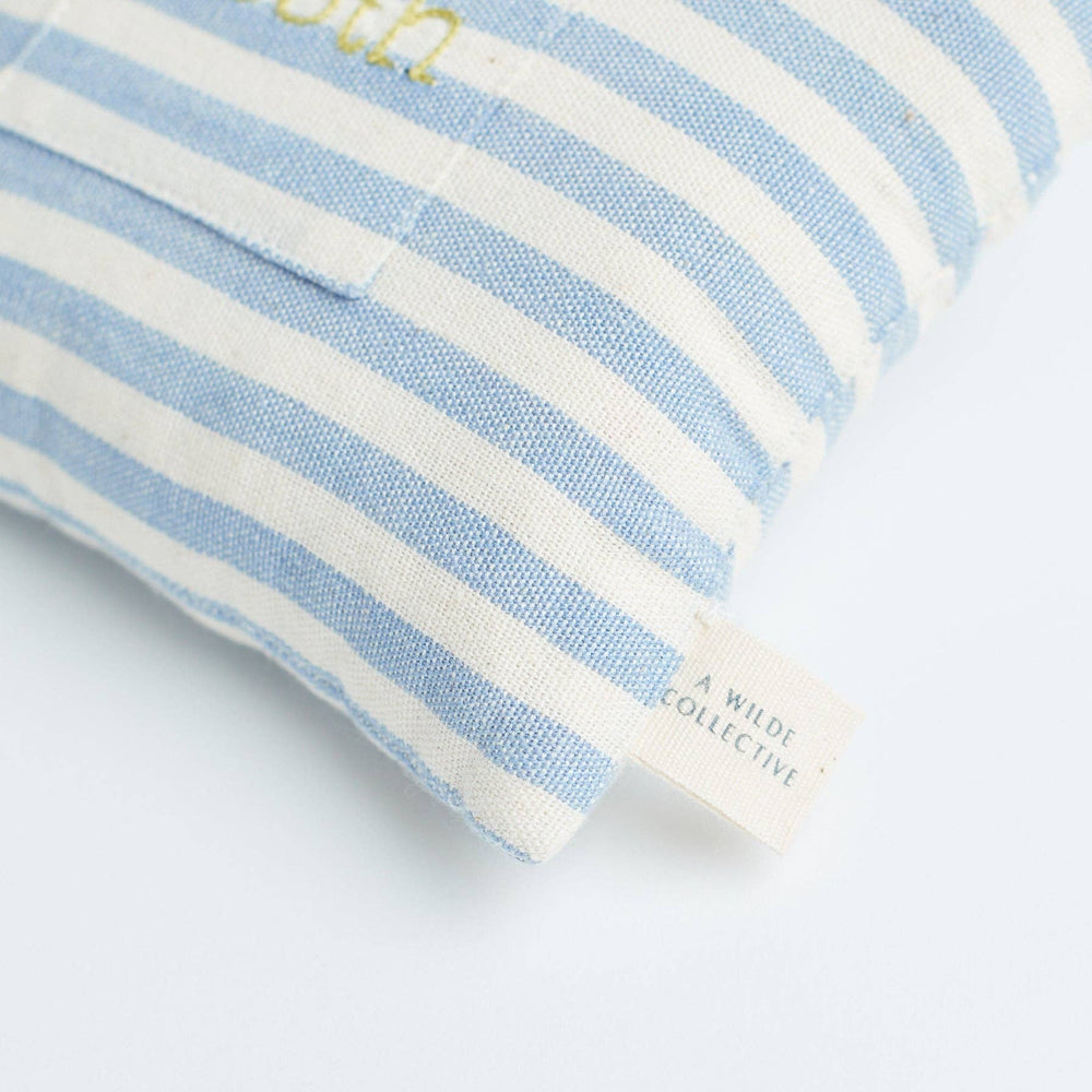 Close-up view showing the striped handwoven cotton fabric and small embroidered pocket of the tooth fairy pillow
