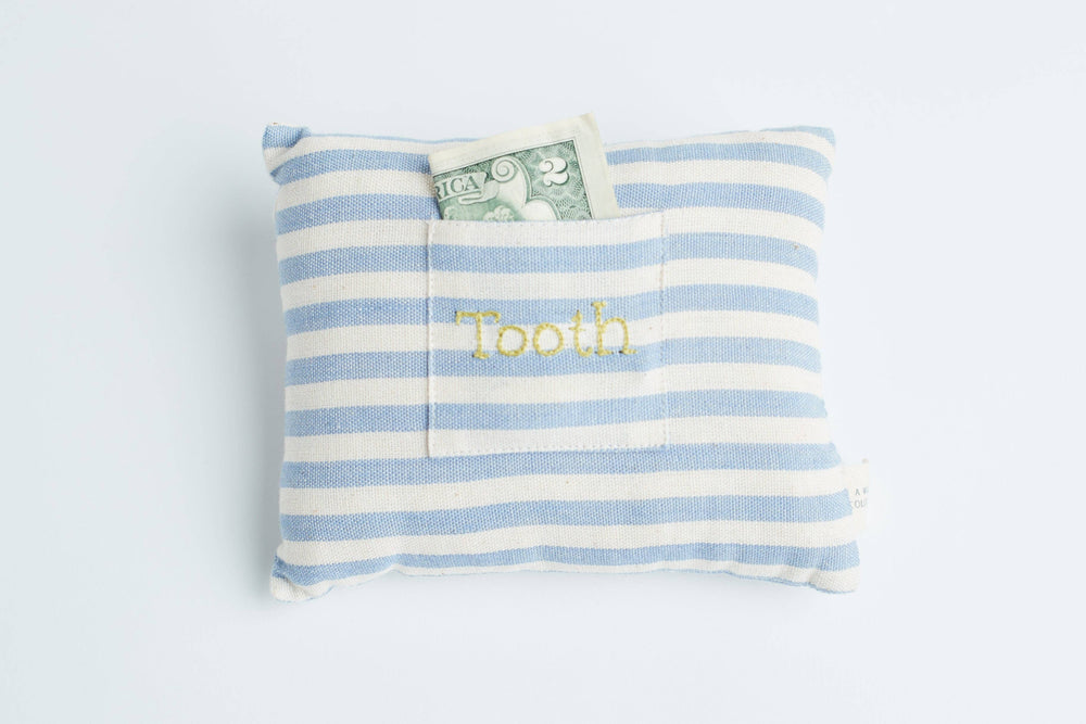 Close-up view showing the striped handwoven cotton fabric and small embroidered pocket of the tooth fairy pillow
