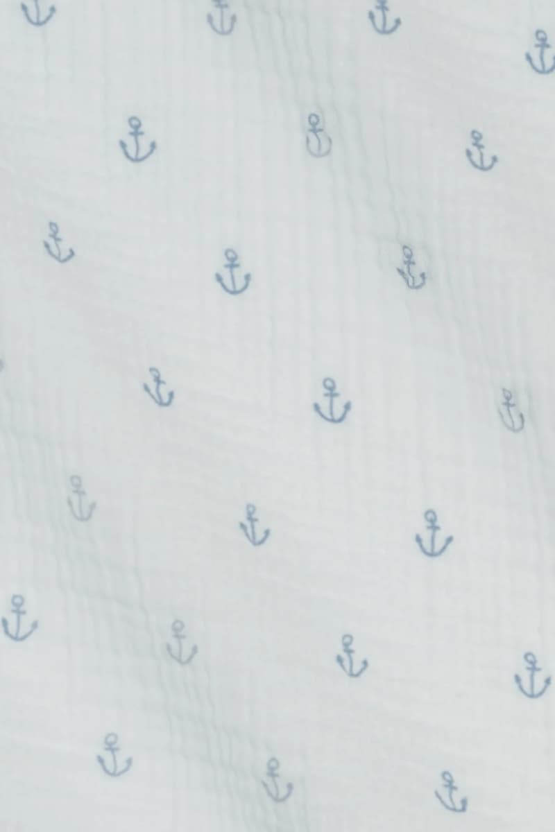 Close-up of anchor print on Colored Organics Kendi Muslin Swaddle — navy anchor motifs on light blue organic cotton gauze