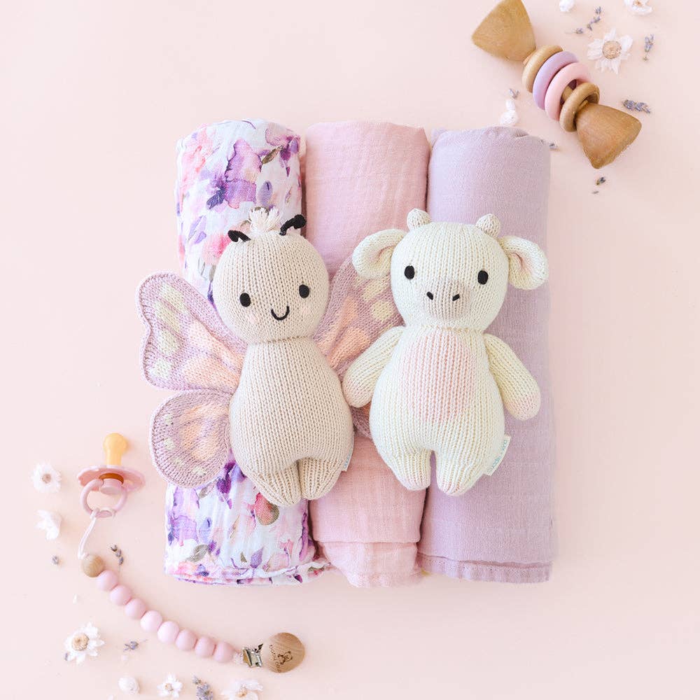 
                      
                        Styled flatlay featuring Cuddle + Kind Baby Butterfly and Baby Cow dolls, displayed with natural and cozy nursery props
                      
                    