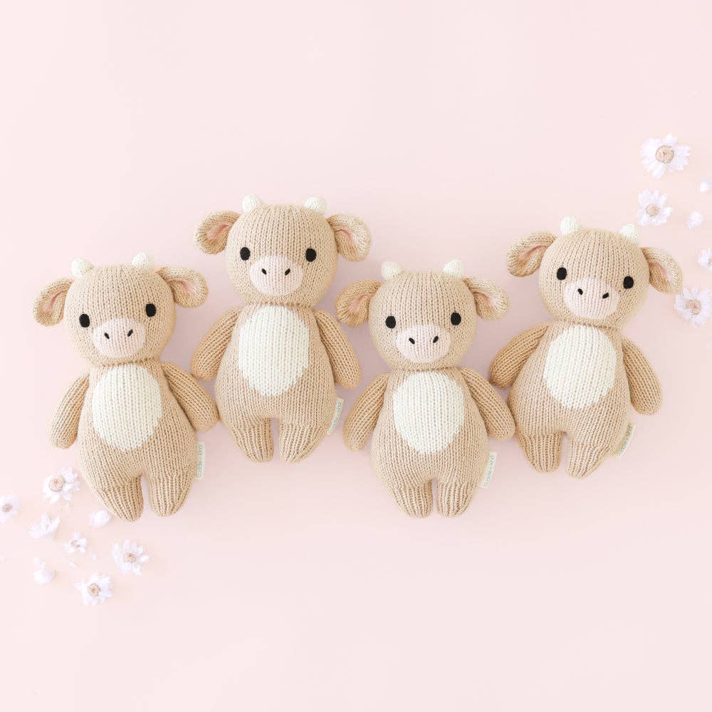 
                      
                        Four Cuddle + Kind Baby Cow dolls lined up, showing hand-knit consistency and charming heirloom-quality details
                      
                    