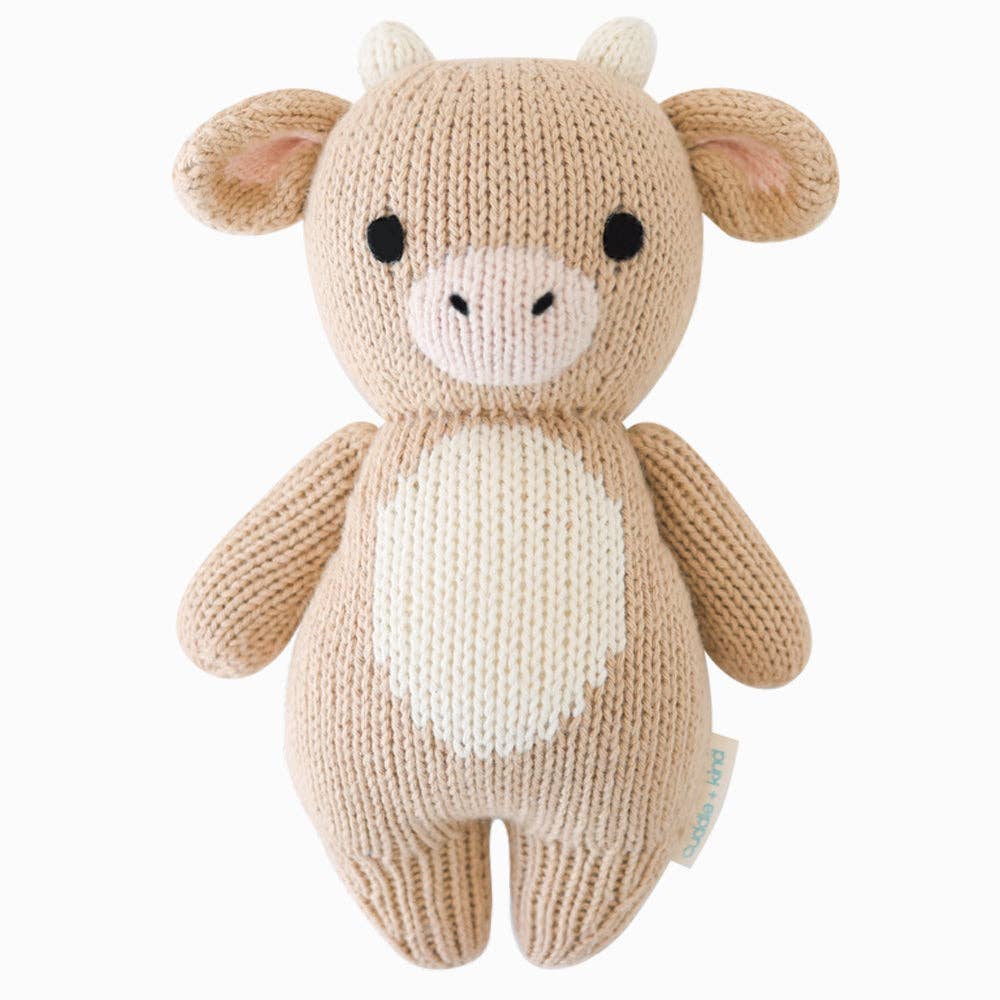 Front flatlay of Cuddle + Kind Baby Cow (Jersey), hand-knit 7” cotton plush animal doll, perfect for newborn gifts and nursery decor