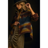 Fall jacket with multicolored southwestern pattern, worn open over a beige ruched dress, styled with a beige wide-brim hat.