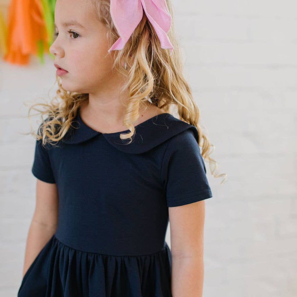 
                      
                        Close-up of the Elizabeth Dress in navy showing the soft wrap-around collar and neckline detail.
                      
                    