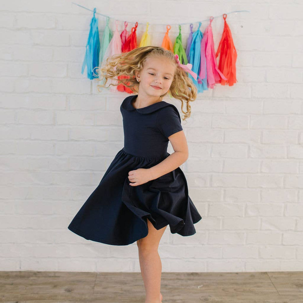 
                      
                        Close-up of the Elizabeth Dress in navy showing the soft wrap-around collar and neckline detail.
                      
                    