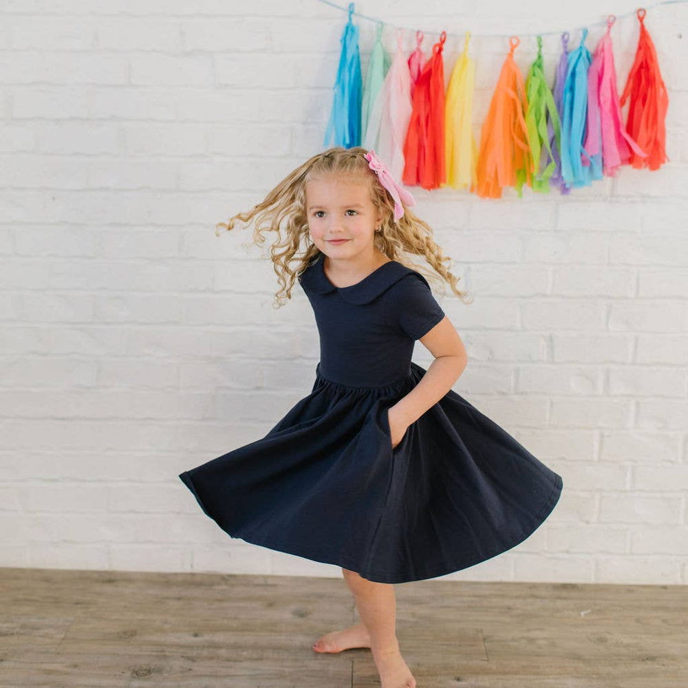 
                      
                        Toddler twirling in the Elizabeth Dress in navy, showing movement of full-circle skirt.
                      
                    