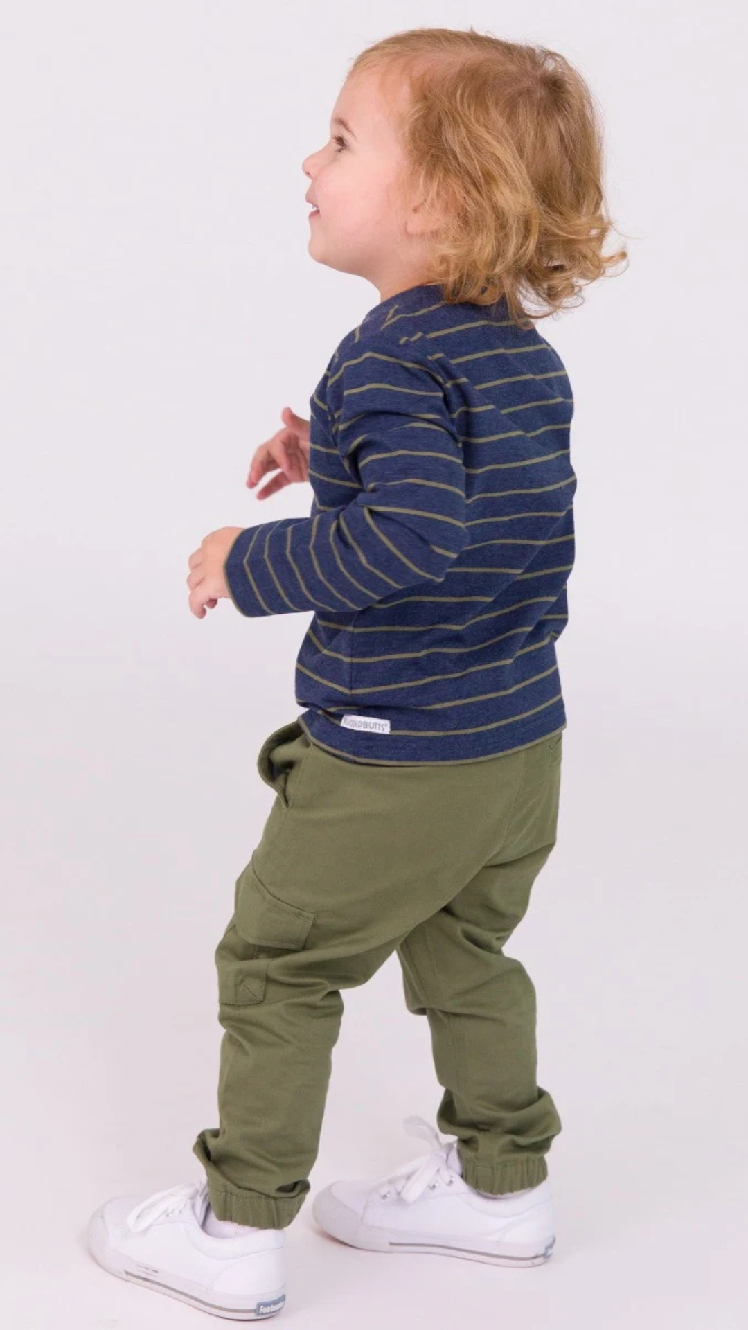 Energetic child in the Boys Dusty Olive Stripe Knit Long Sleeve Henley Tee, captured in a vibrant studio setting.