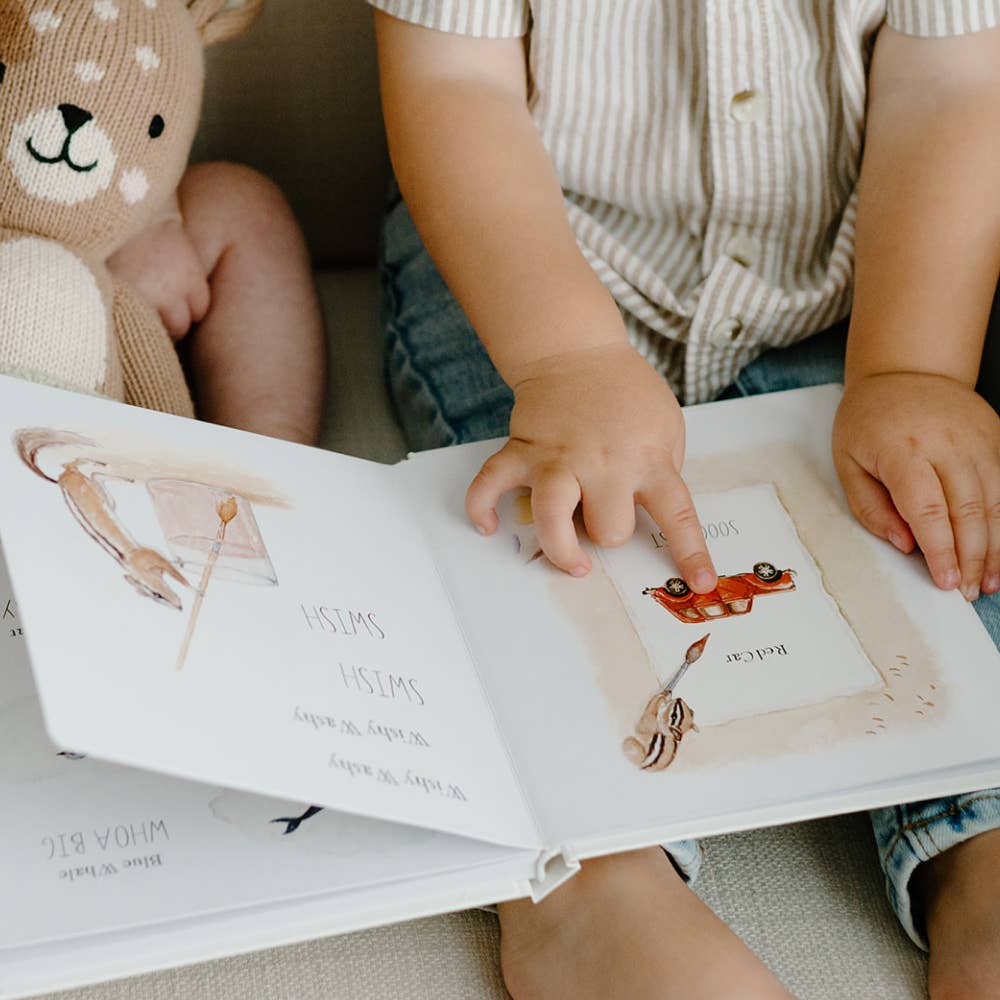 Child turning pages in an illustrated children's first words book.