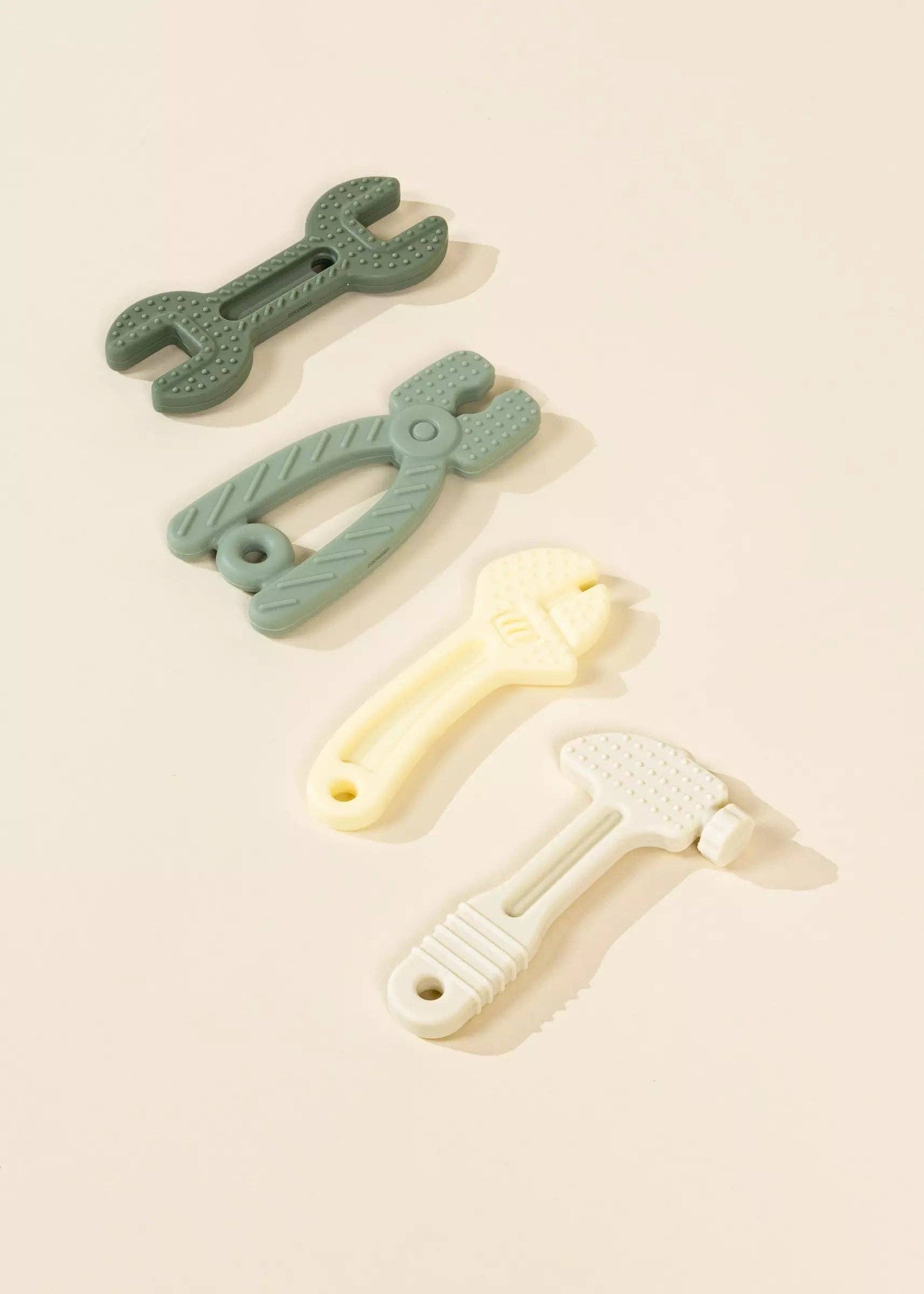 Flatlay image of Set of 4 Silicone Tools Baby Toys, soft textured shapes made of food-grade silicone, ideal for baby sensory development