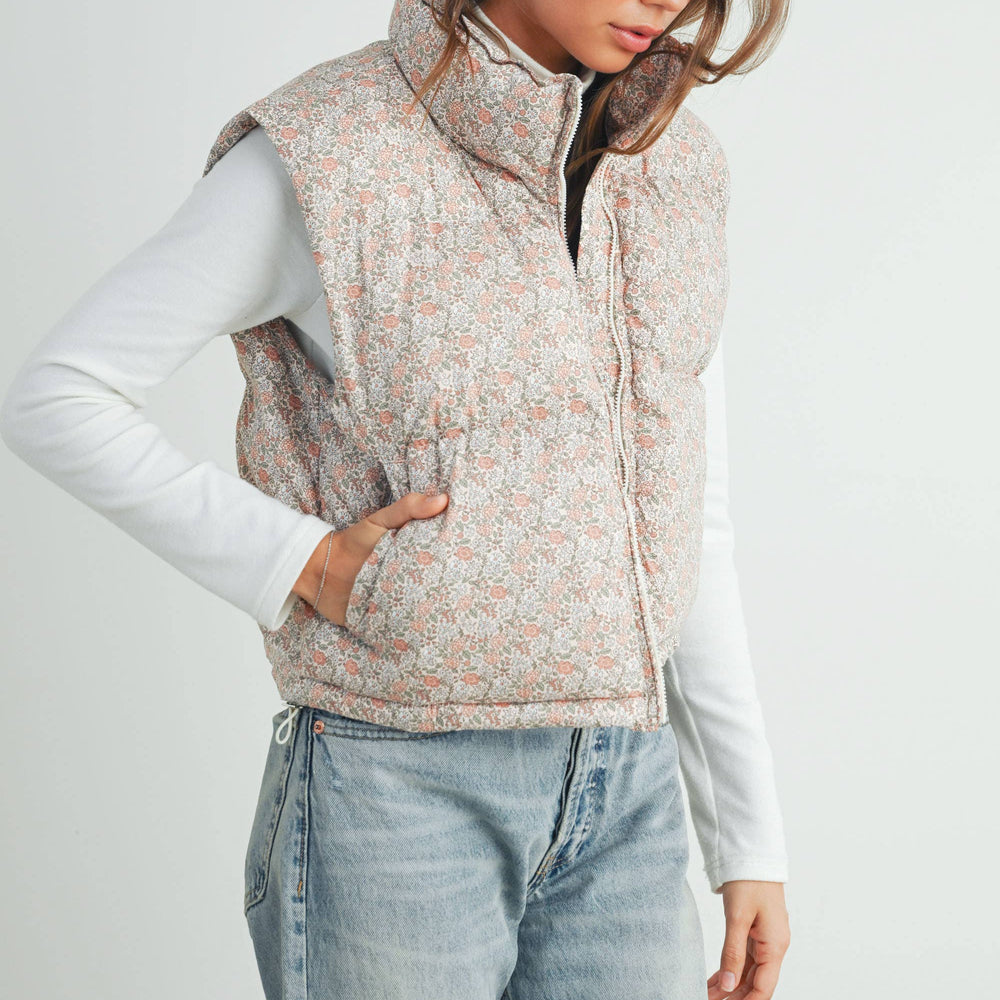 
                      
                        Studio image of model walking forward in floral puffer vest and jeans, showcasing movement and fit
                      
                    