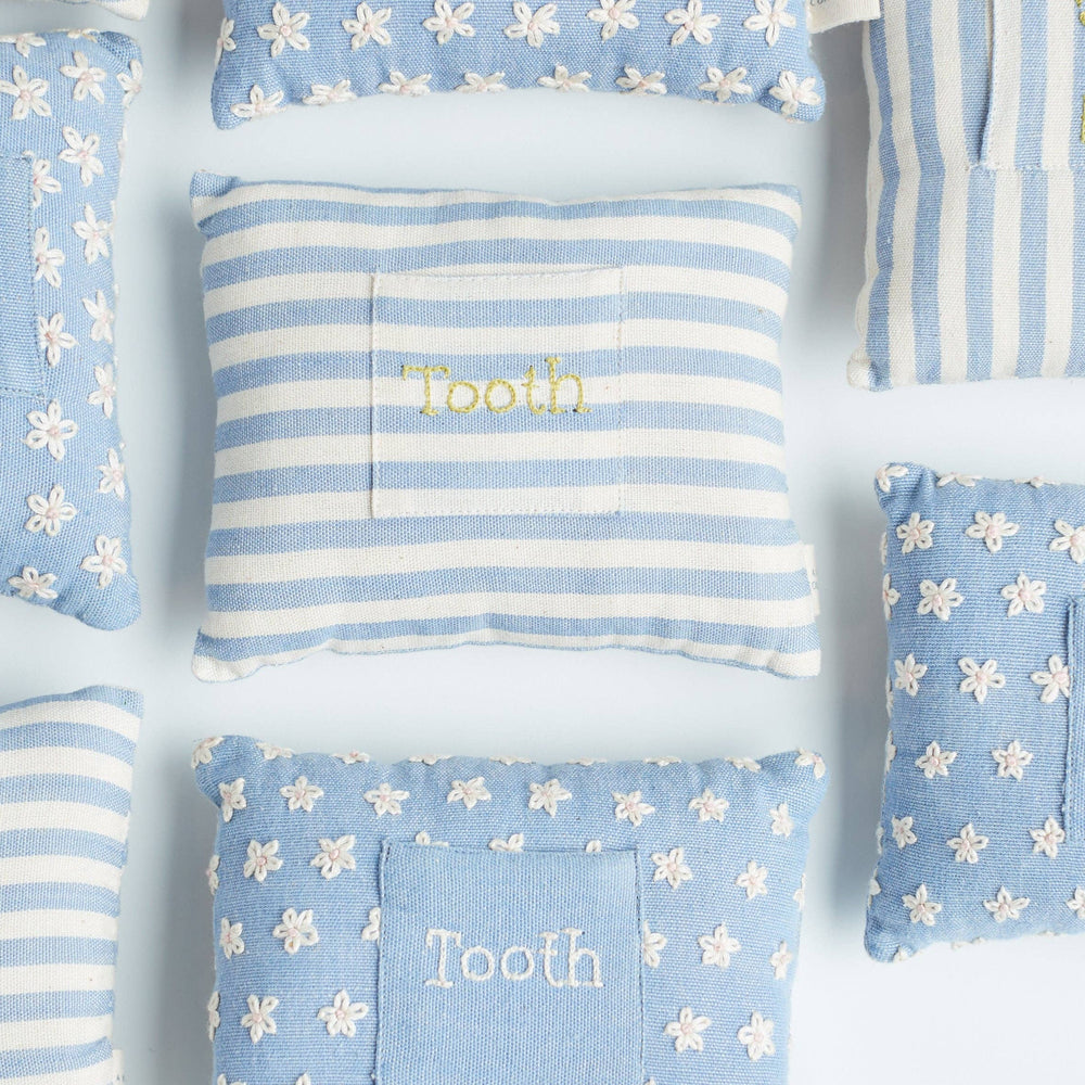 
                      
                        Flat lay of the front of the handwoven tooth fairy pillow showing delicate floral pattern and front pocket alongside striped version
                      
                    
