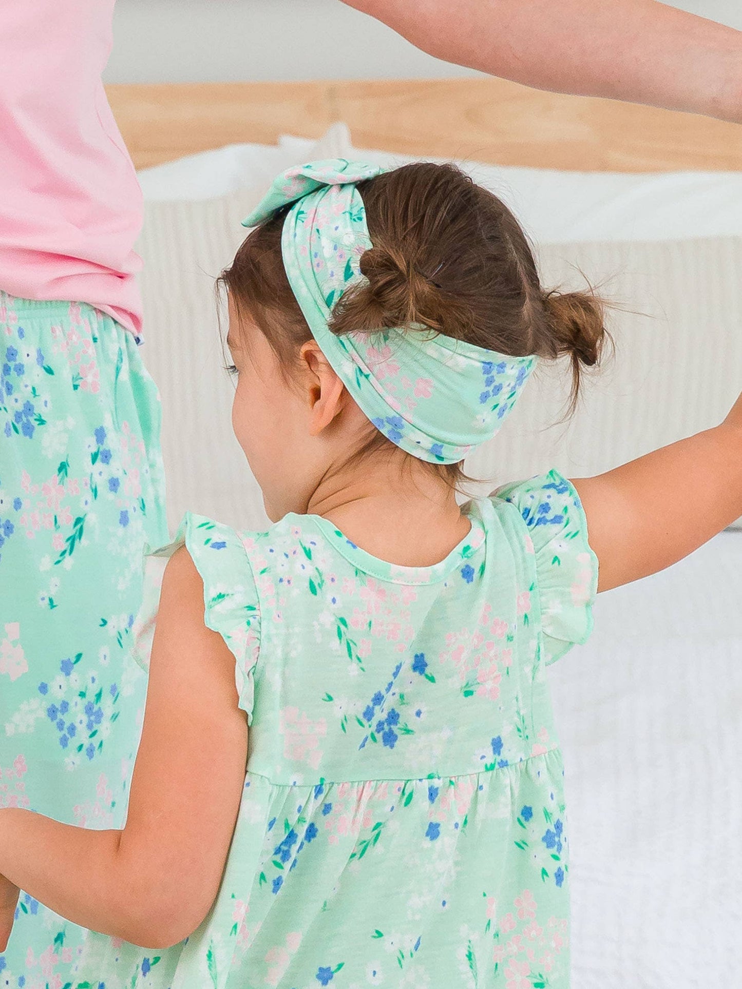 Side and back view of girl wearing mint meadow big bow headband, highlighting full bow shape and secure fit
