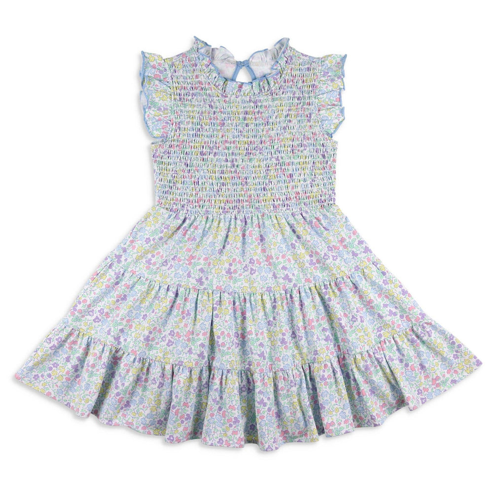 Flat lay of the Girls Smocked Twirl Dress – Kiawah, featuring hand-smocked bodice, ruffle sleeves with blue trim, and a twirl-friendly tiered skirt in a floral and fruit print.