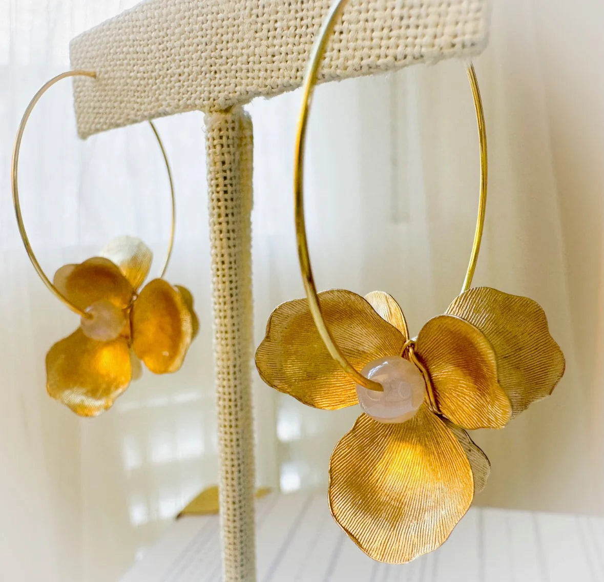 Close‑up of textured brass petals and mystic agate stone on Golden Petals hoops.