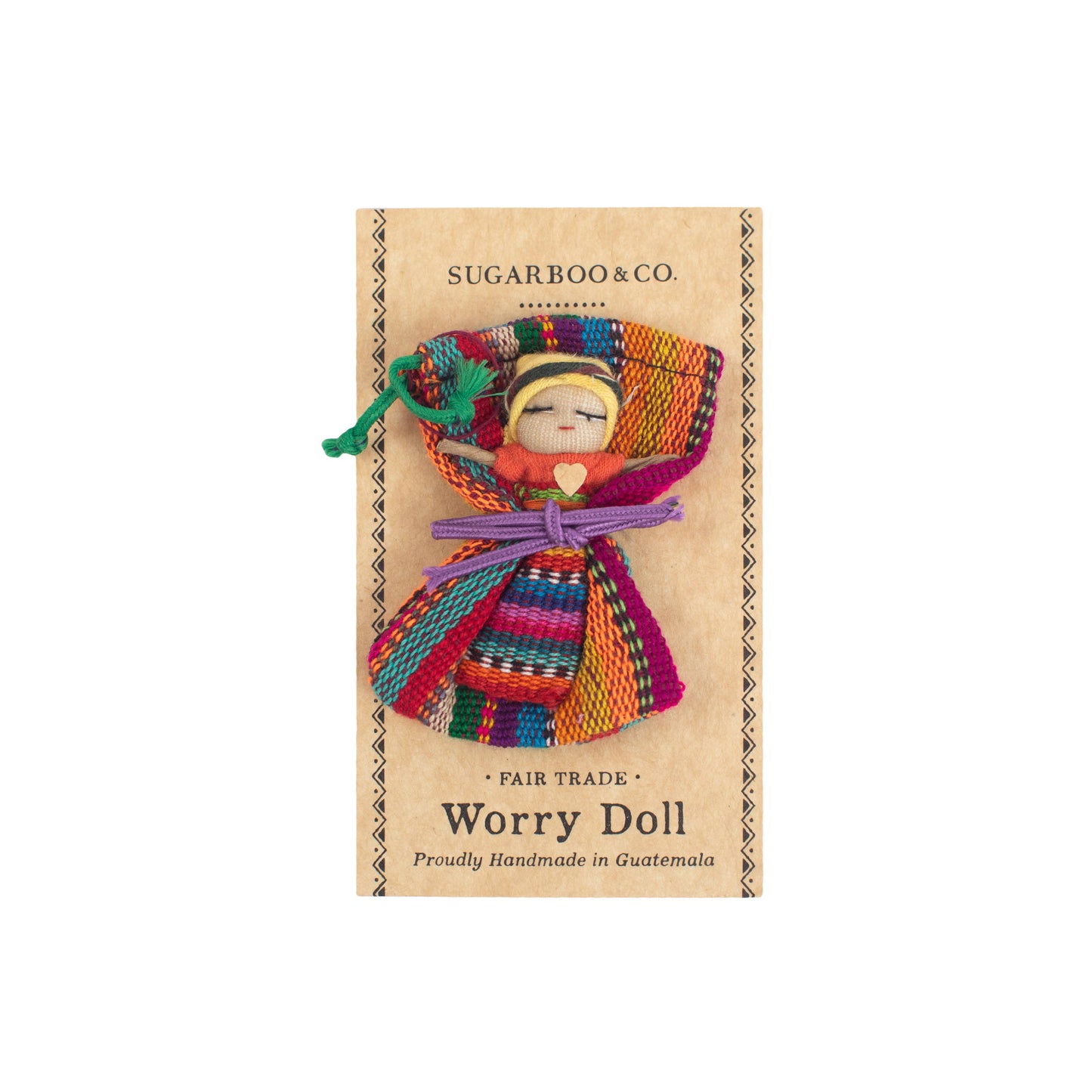 Flat lay of a handmade 2-inch Guatemalan Worry Doll resting beside its packaging, showcasing traditional Mayan craftsmanship and colorful folk art.