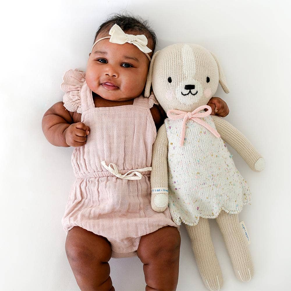 
                      
                        Happy baby snuggled in with Mia the Dog cuddle+kind doll, showing soft and safe cuddly texture
                      
                    