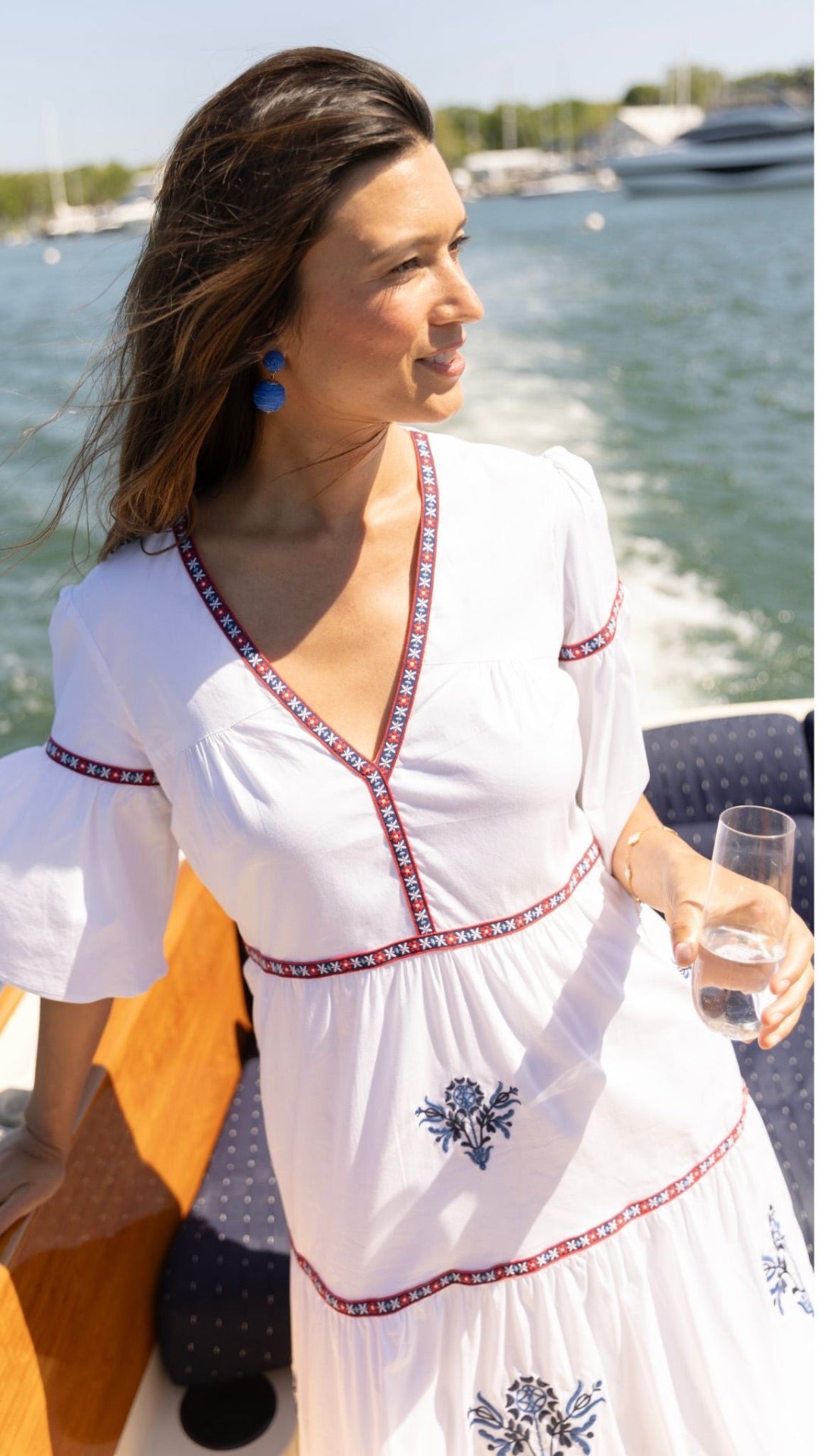 Woman wearing the Ivy Coast Harbor Dress on a boat, enjoying a sunny summer day