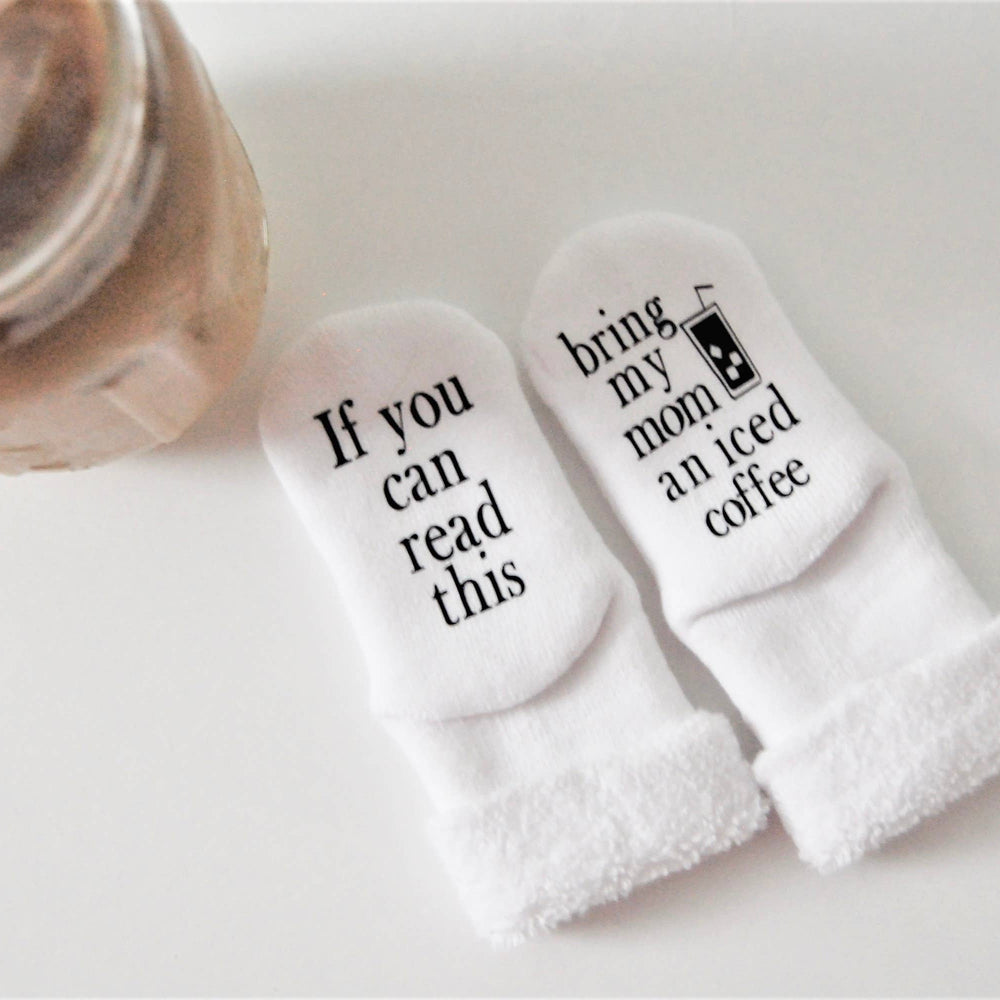 
                      
                        Baby socks with iced coffee message folded inside a gift box as part of a new baby present.
                      
                    