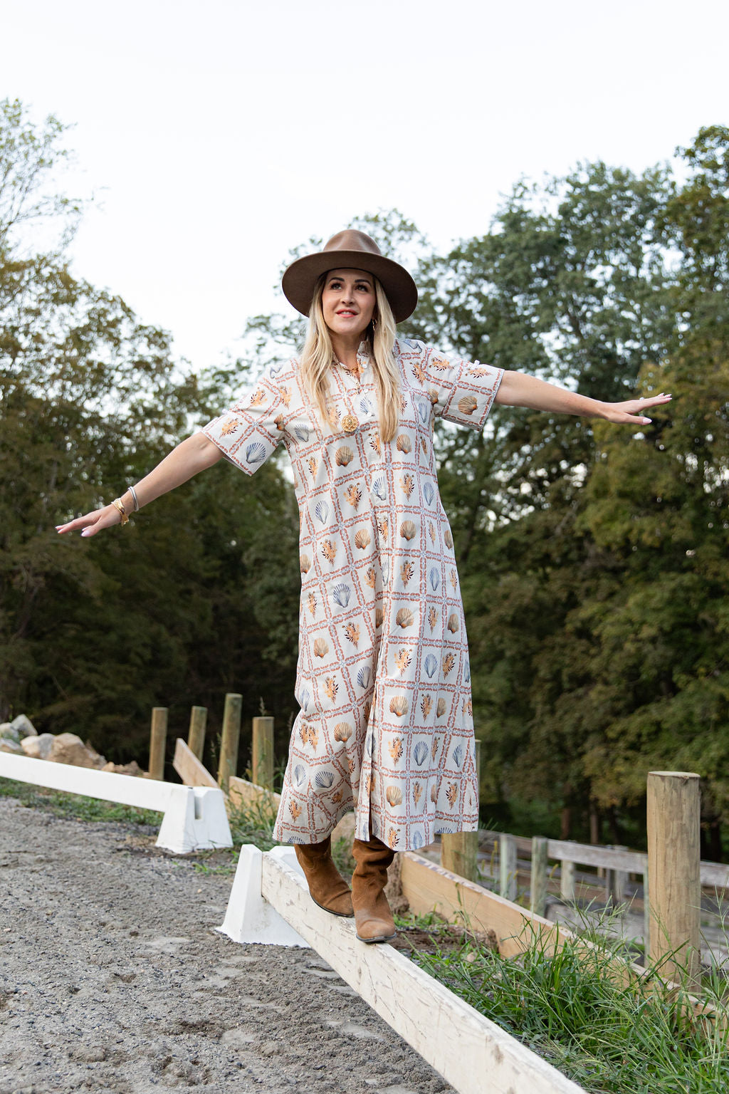 Woman wearing Ivy Coast Maren seashell print UPF 50+ shirt dress, front view, mid-length