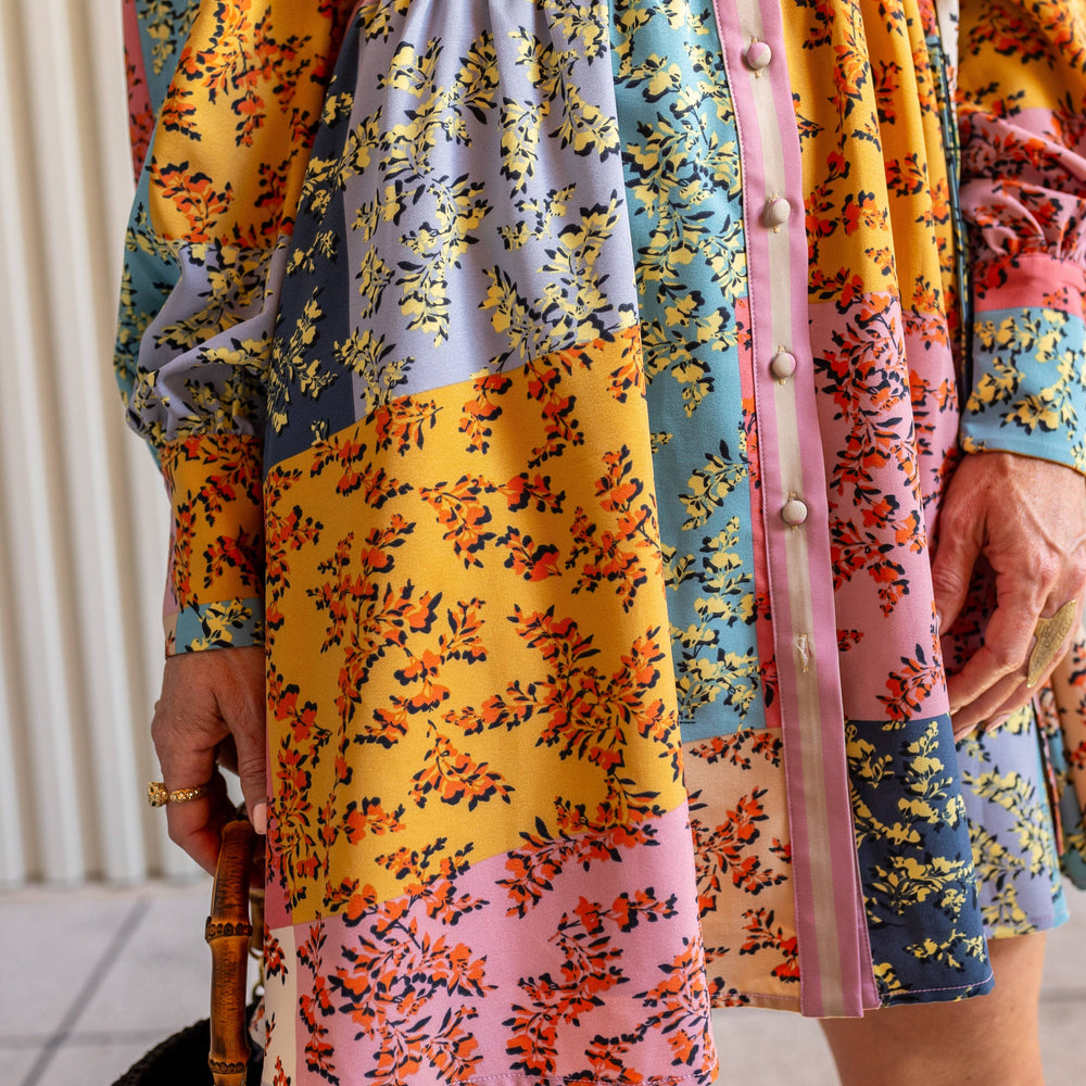 
                      
                        Close-up of The Jules Dress skirt showing floral pattern and flowy mid-thigh hemline detail.
                      
                    