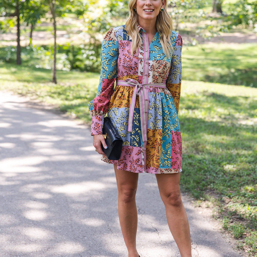 The Jules Dress in motion, showcasing its flowy skirt and floral pattern in a garden setting.