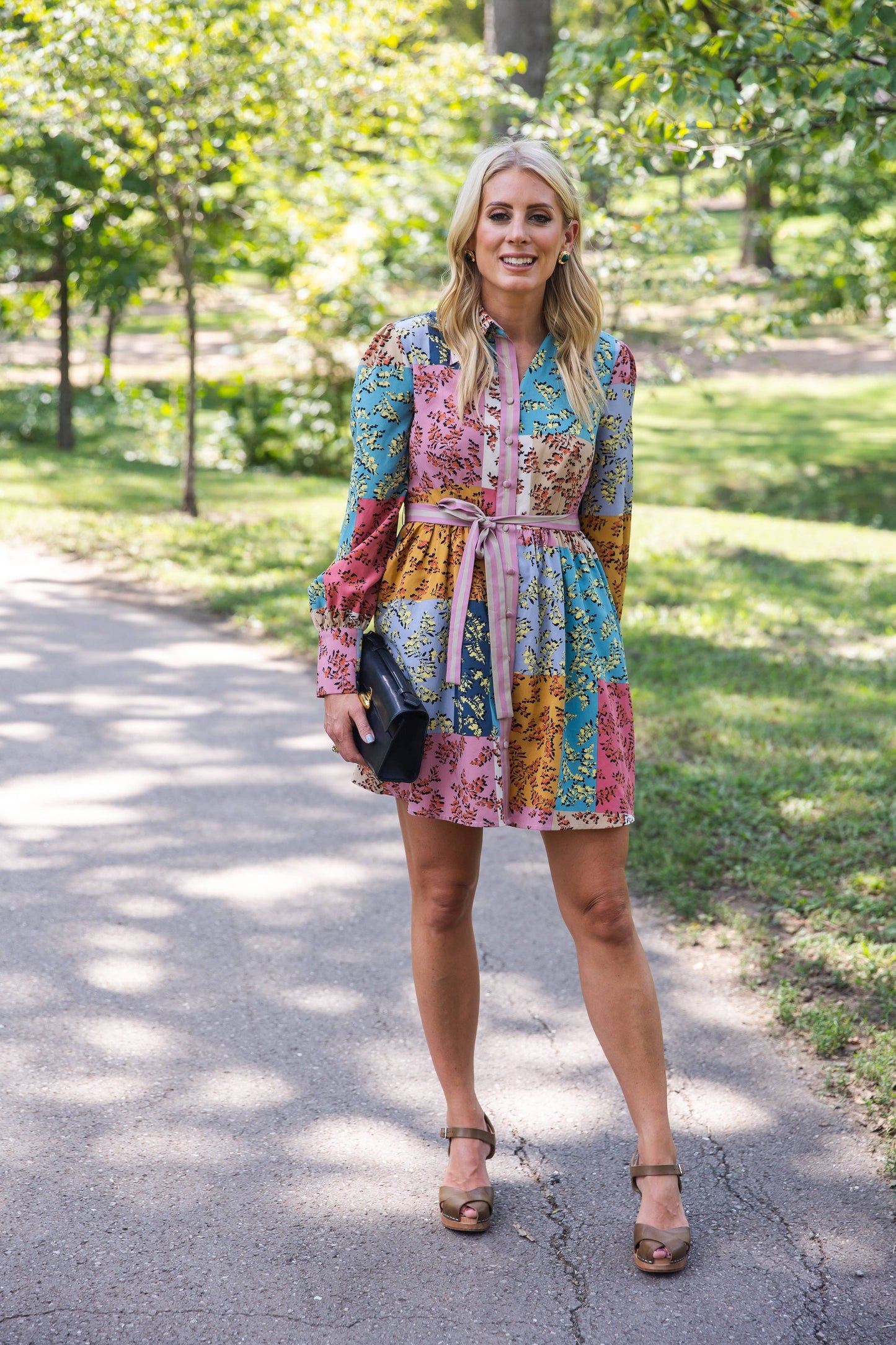 The Jules Dress in motion, showcasing its flowy skirt and floral pattern in a garden setting.