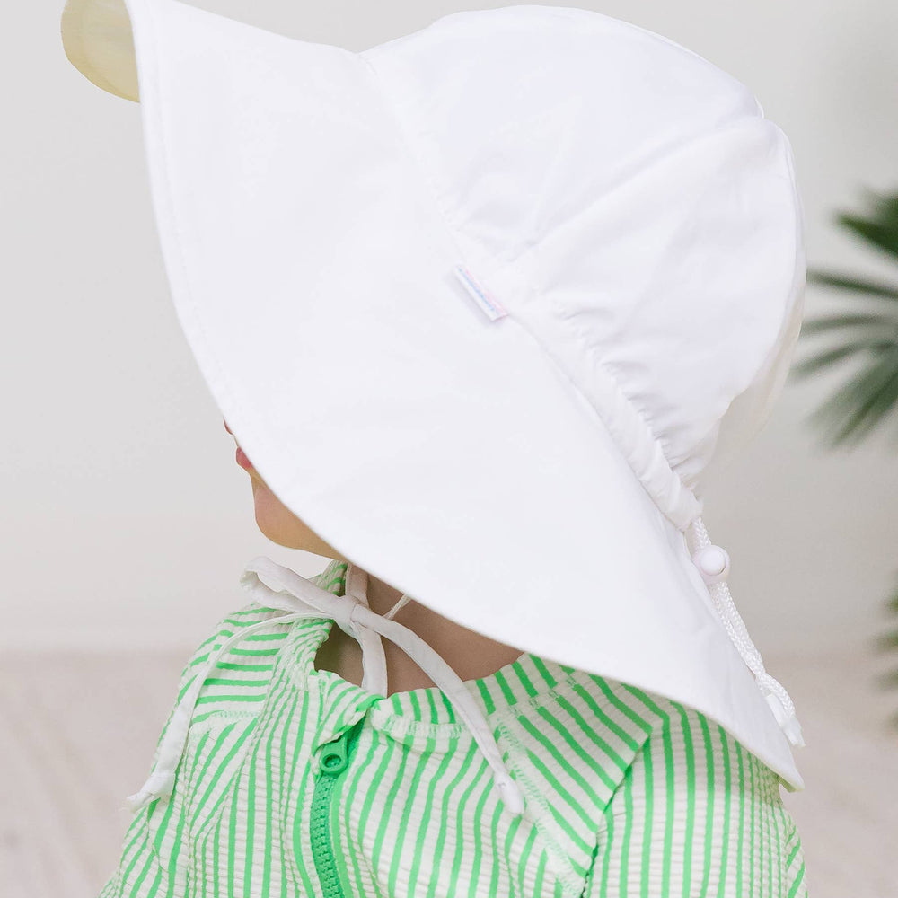 Close-up side view of kids white UPF 50+ sun hat on child, showing lightweight fabric and chin tie