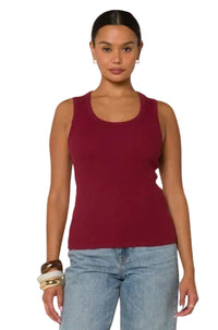 Berry Fitted Tank in deep red cotton, sleeveless design with a scoop neckline, worn by a woman with light blue jeans.