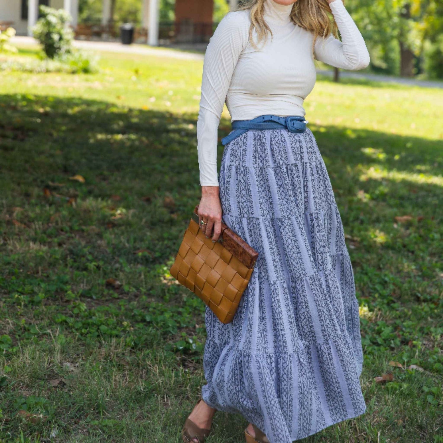 Lifestyle shot of model wearing Lily Skirt with sneakers and white top