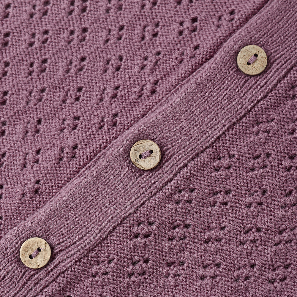 Close-up of coconut button closure and knit texture on the Mulberry Long Sleeve Bubble Romper by Quincy Mae.