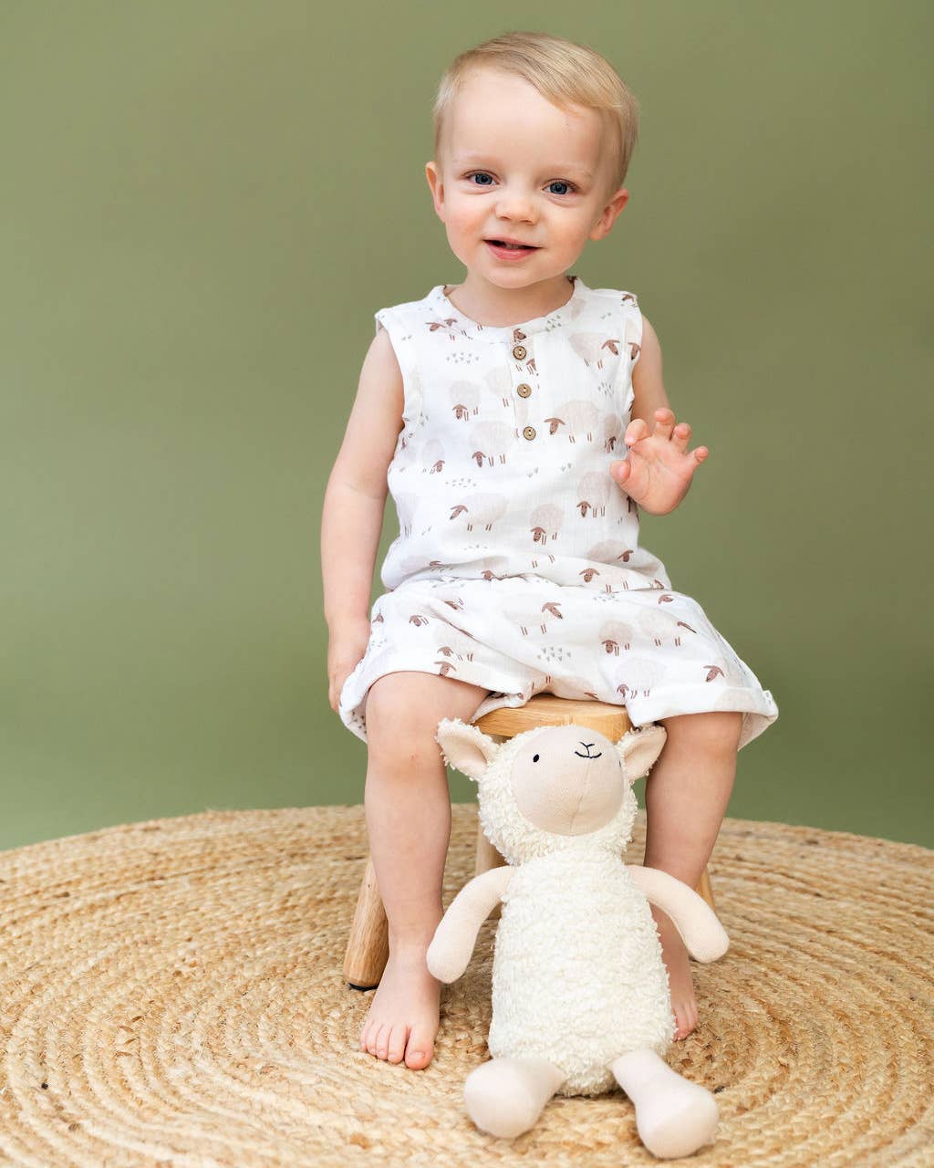 Baby holding organic knit lamb plush toy