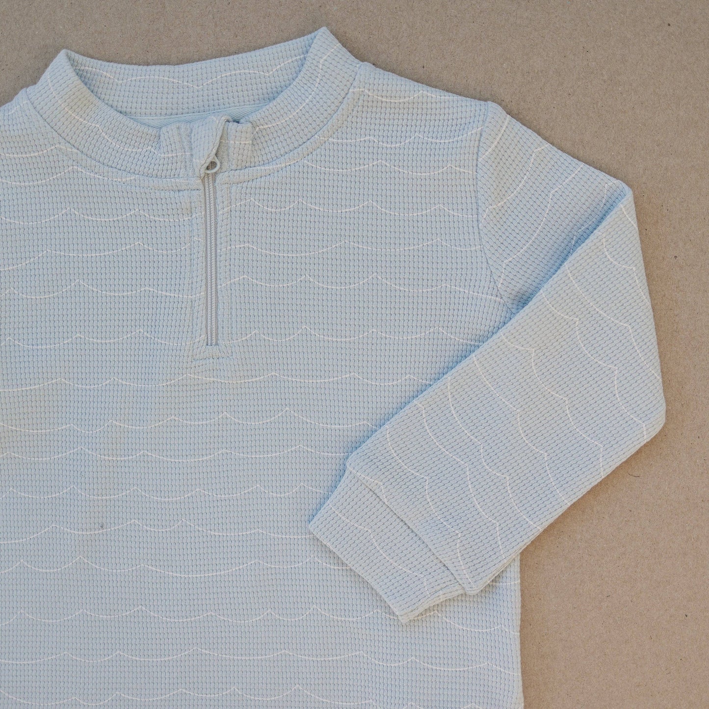 Close-up of organic cotton waffle knit fabric quarter zip