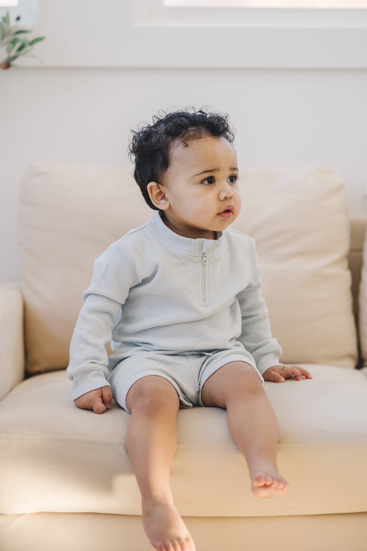 Child wearing organic waffle knit quarter zip during play
