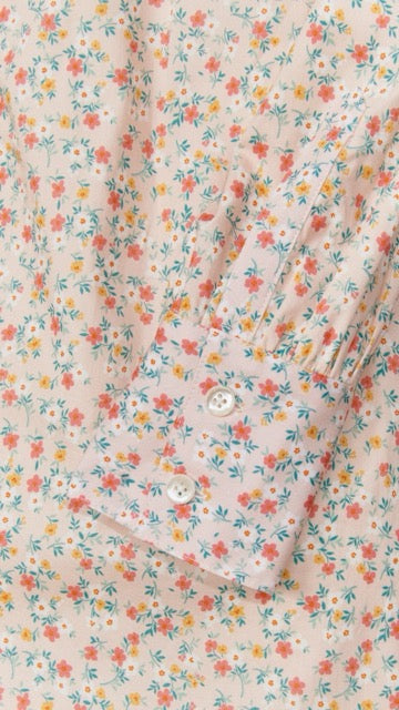 Close-up of the Maris dress showing floral print and pleated cuff detail with mother-of-pearl button