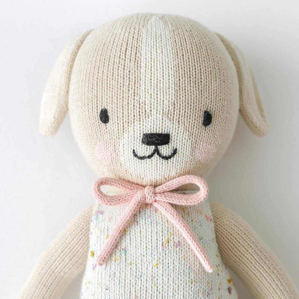 
                      
                        Close-up of Mia the Dog’s hand-knit pink bow showing fine craftsmanship and soft cotton texture
                      
                    