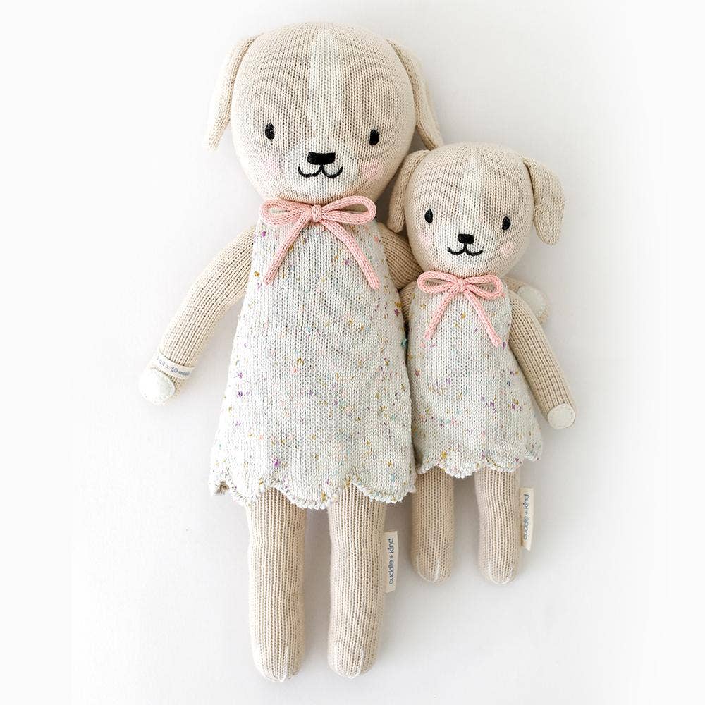 
                      
                        Styled flatlay of Mia the Dog dolls in regular and little sizes positioned side by side
                      
                    