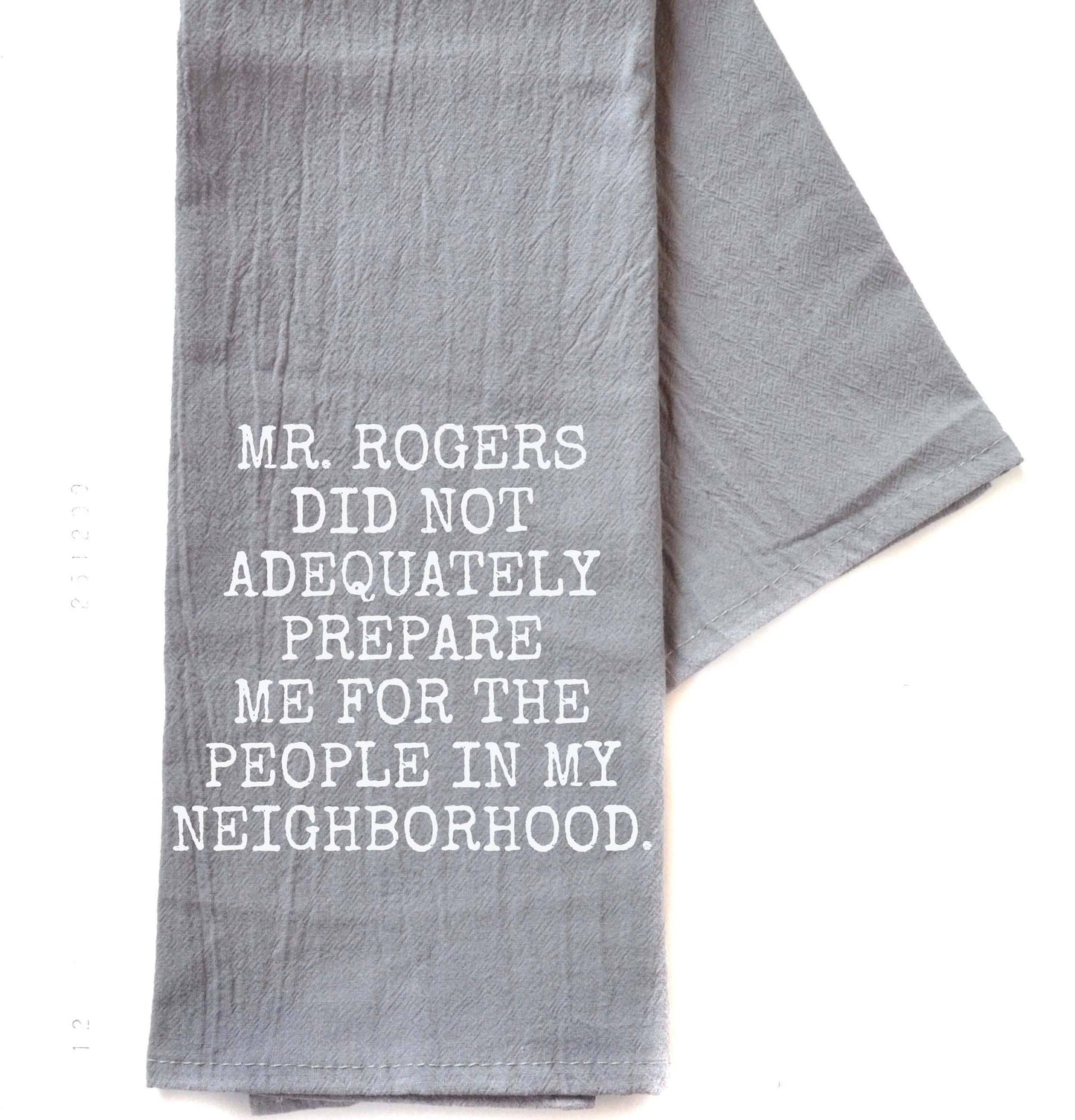 A humorous "Mr. Rogers Did Not Adequately Prepare Me For The People In My Neighborhood" tea towel, featuring bold, playful text. Made from high-quality cotton, this towel adds a touch of fun and personality to your kitchen. A perfect gift for fans of Mr. Rogers, or anyone who enjoys quirky, light-hearted home decor. The design is both practical and comical, perfect for drying dishes or hanging in your kitchen as a conversation starter. This towel combines style and humor, bringing a little laughter to every