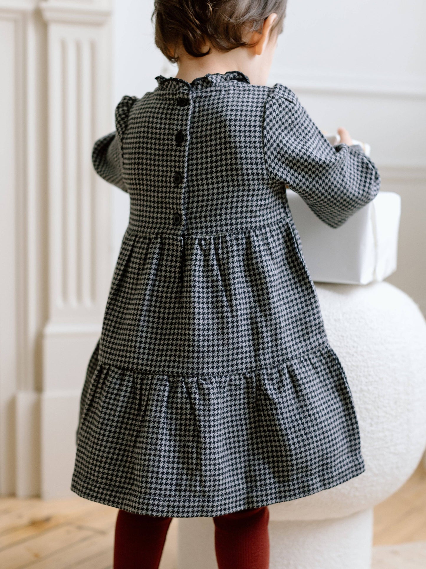 Back view of Neela Flannel Dress by Colored Organics in organic cotton, showing back button placket and gathered tiered skirt