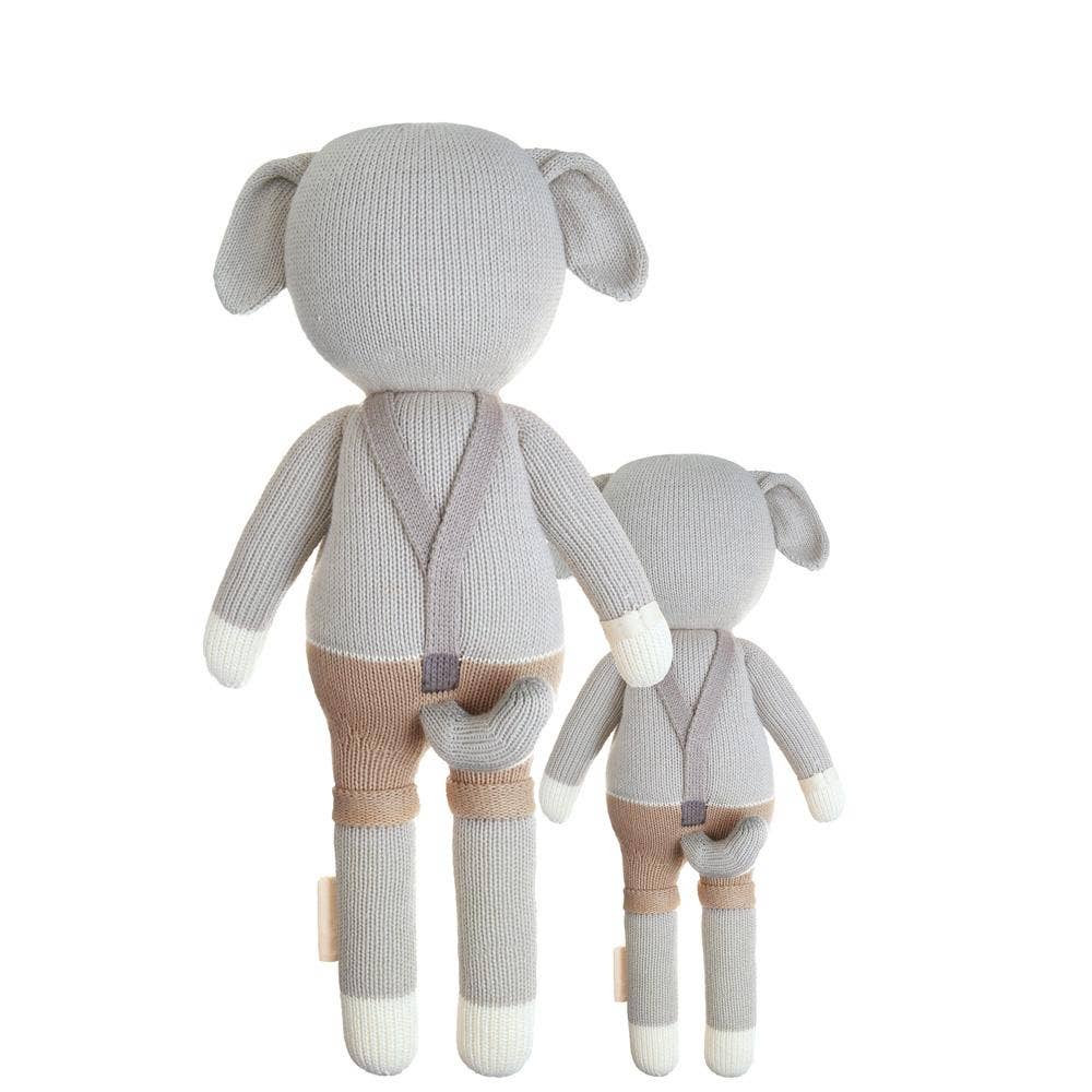 Flatlay of Noah the Dog cuddle+kind dolls in both sizes shown from the back, highlighting handcrafted details and soft natural yarn.