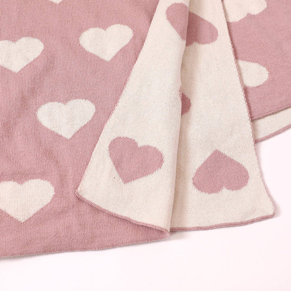 
                      
                        Close-up of heart motif on bi-color jacquard knit baby blanket made from organic cotton by Viverano
                      
                    
