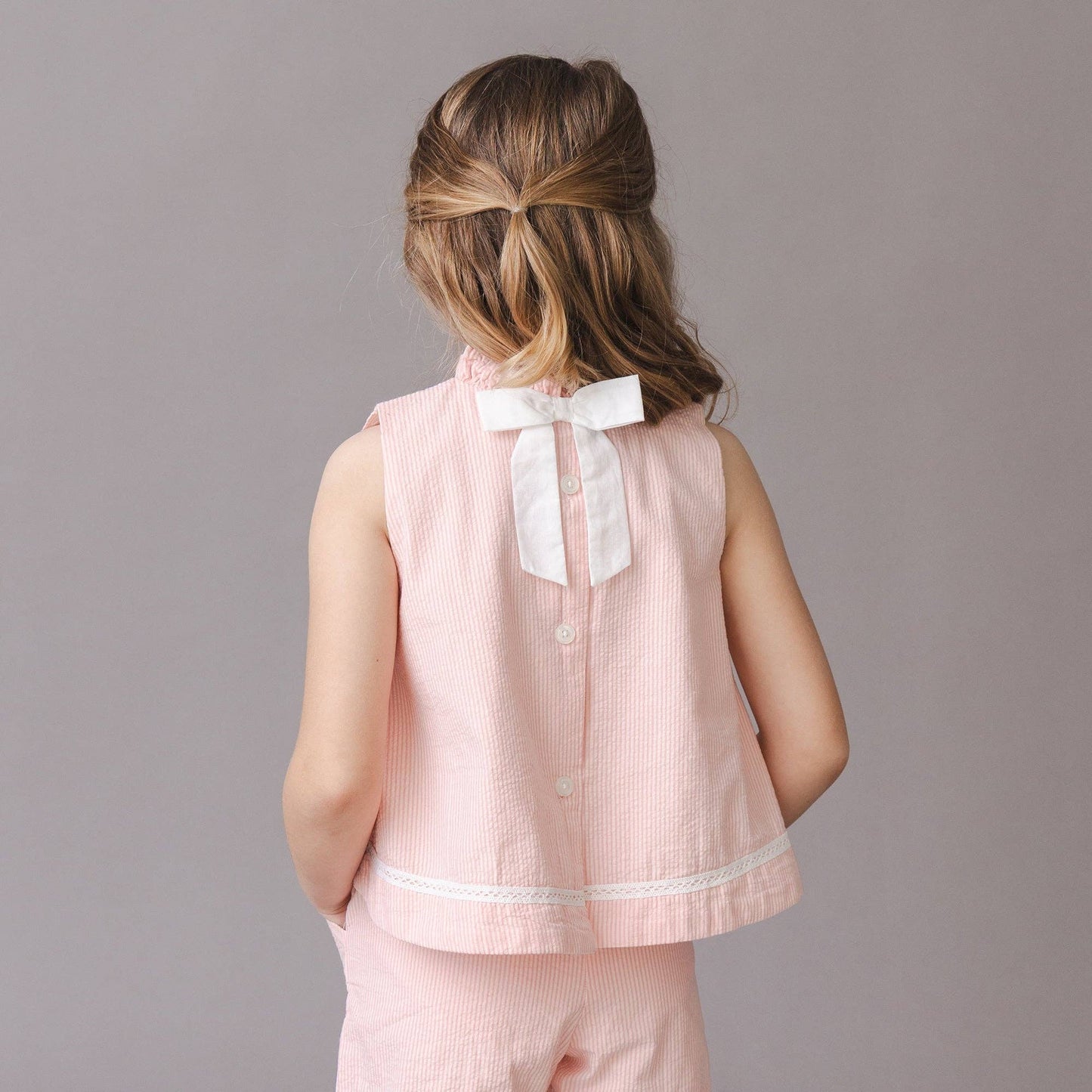 Girl wearing Organic Ruffle Neck Seersucker Top in Rose — Grace & Haven, Essex CT