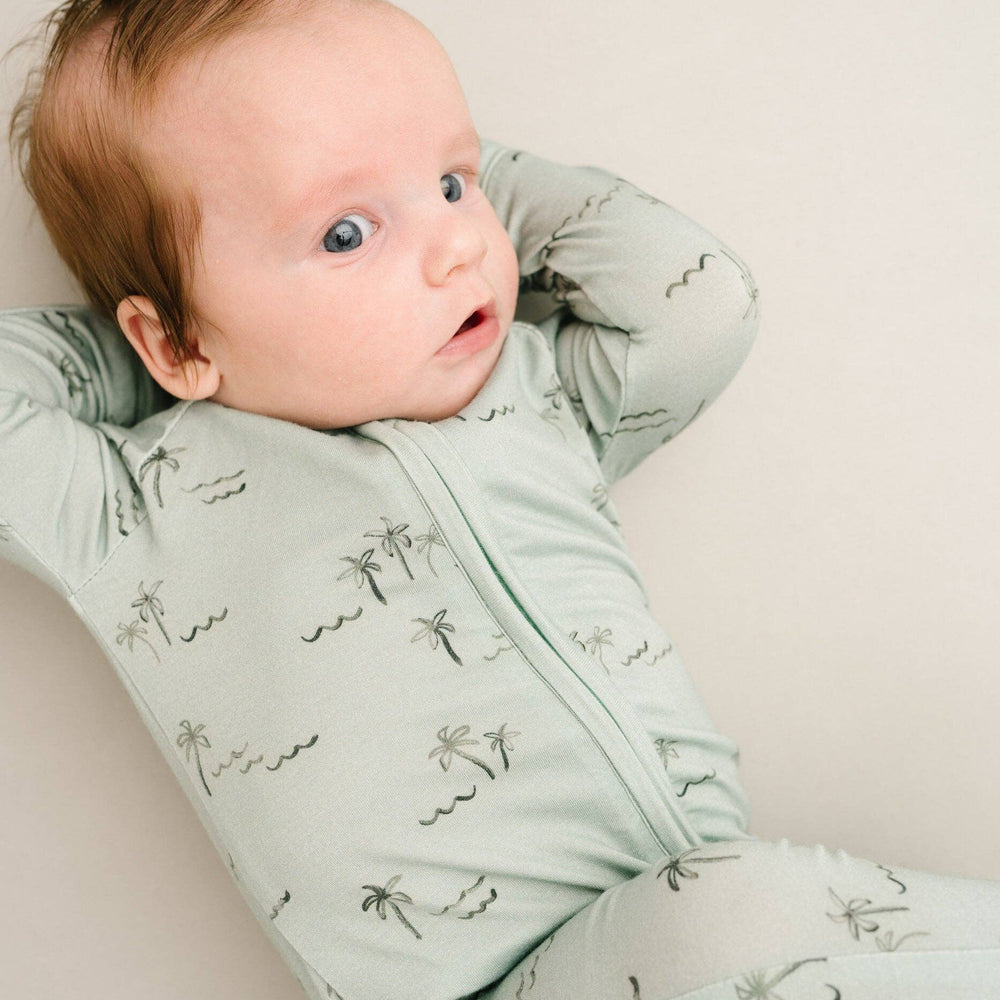 
                      
                        Baby curled up in crib wearing Palm Breeze Bamboo Sleeper, demonstrating cozy comfort.
                      
                    