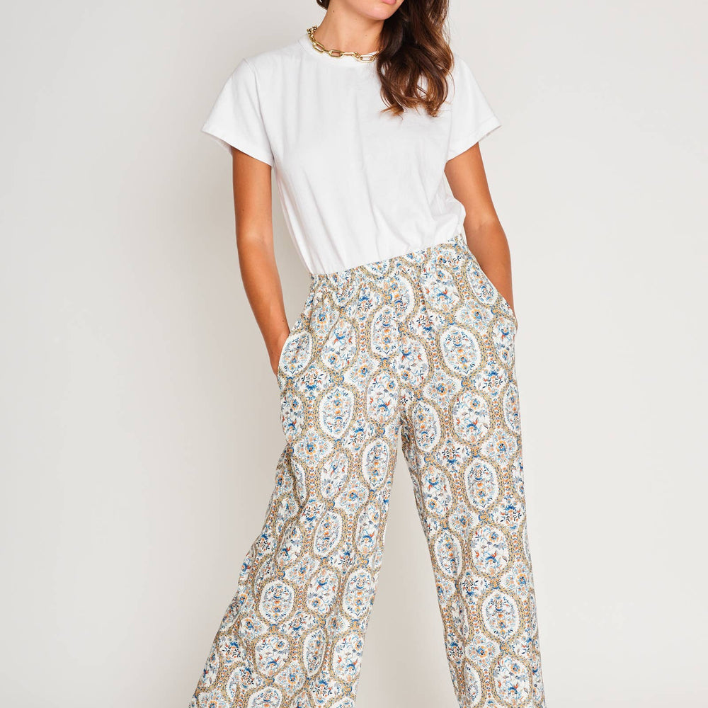 Model in playful pose wearing Paloma Wide Leg Pant in bold Santorini Mosaic print, paired with a neutral tank for effortless summer style