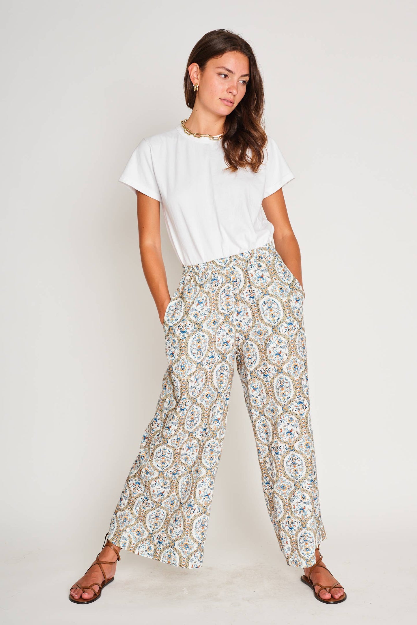 Model in playful pose wearing Paloma Wide Leg Pant in bold Santorini Mosaic print, paired with a neutral tank for effortless summer style