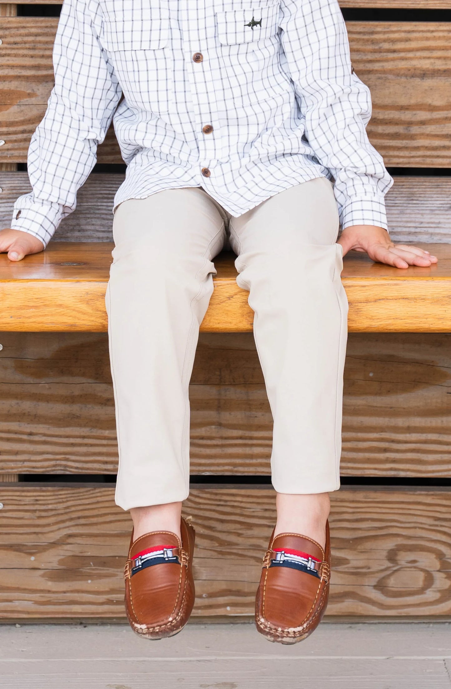 Young boy sitting wearing Par Performance Pants with loafers, highlighting versatile style and comfortable fit for kids.